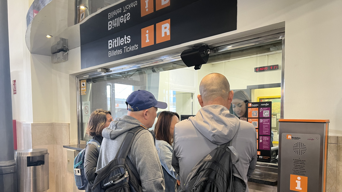 Imagen de gente esperando para comprar un billete de tren.
