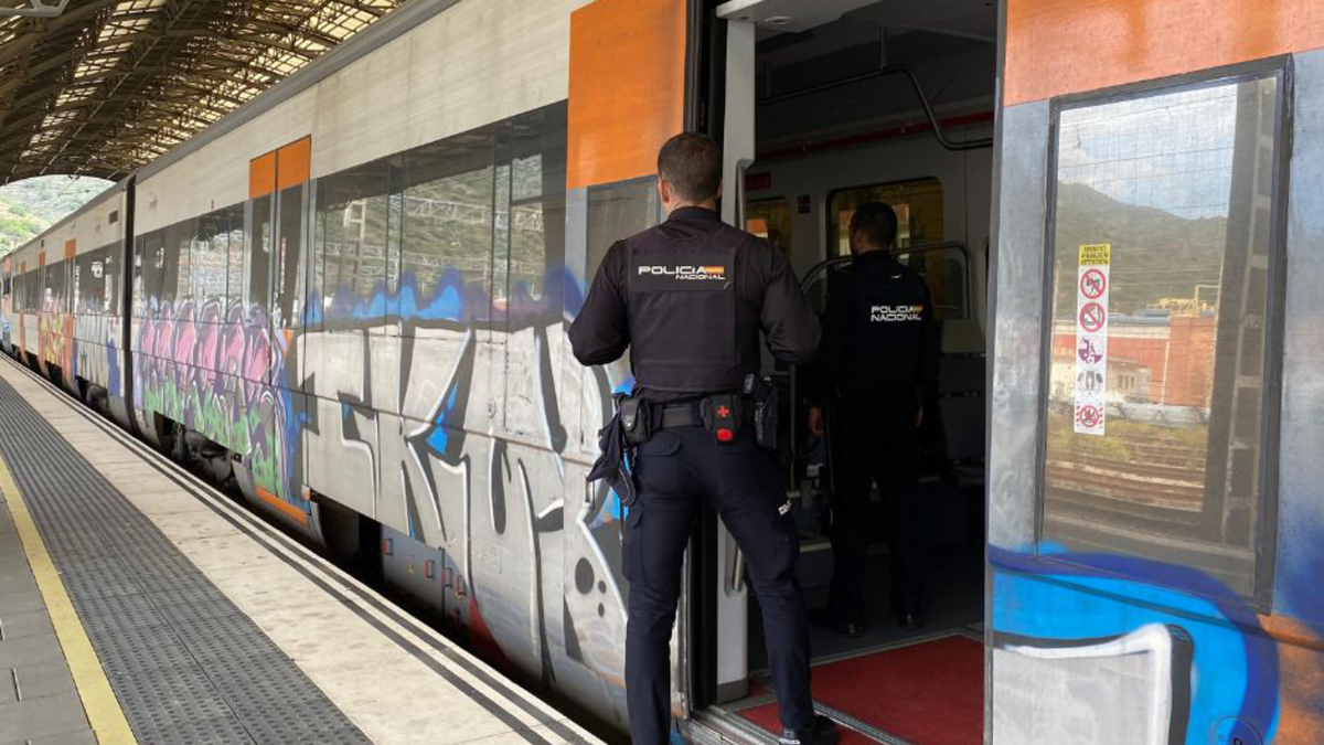 Dos agents de la Policia Nacional pugen en un vagó de tren aturat a l'estació de Portbou per controlar la sortida i entrada de persones a l'Estat.