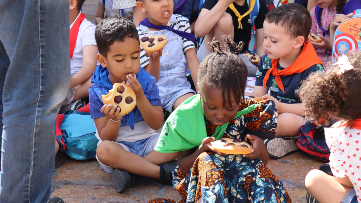 Varios niños comiendo coca con cerezas.