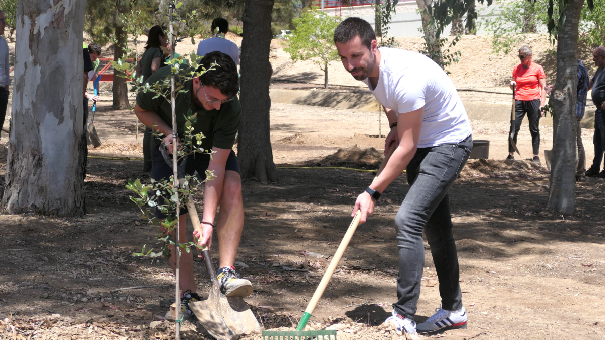 Dos trabajadores del CAT plantando un árbol.