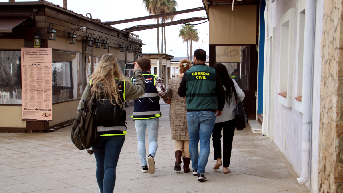 Imagen de archivo de una mujer detenida siendo custodiada por agentes de la Guardia Civil y la Policía Nacional en una operación conjunta en Torredembarra
