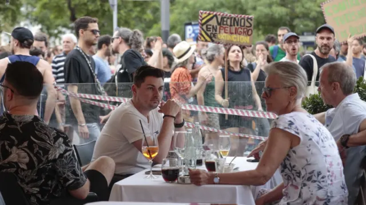 Varios turistas en una terraza de un bar durante la manifestación.