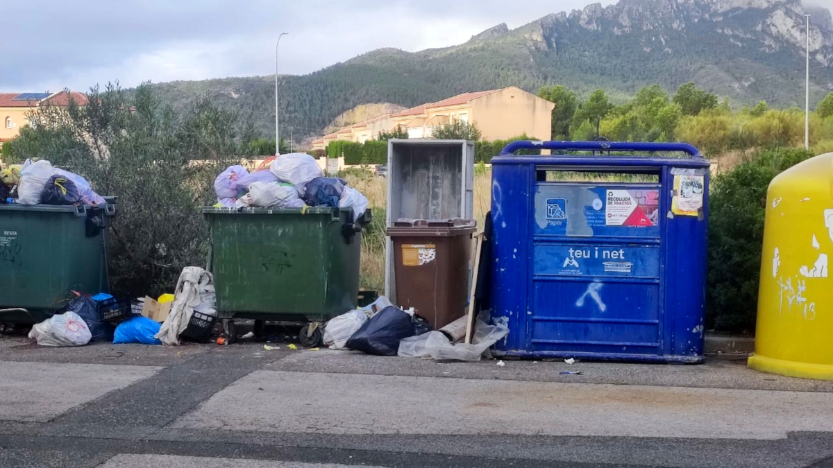Contenidors de rebuig a vessar en una urbanització de Mont-roig del Camp.