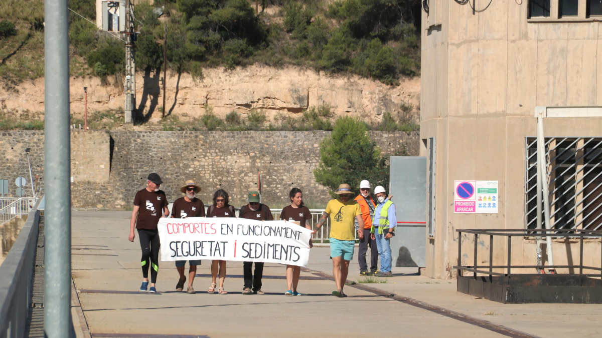 Participants a la Marxa dels Sediments mentre creuen a peu la presa del pantà de Riba-roja.