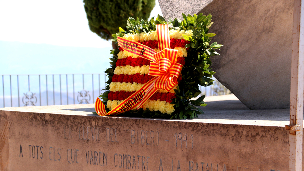 Corona de flores de las instituciones en los pies del Monumento a la Pau de la Cota 705 de Pàndols.
