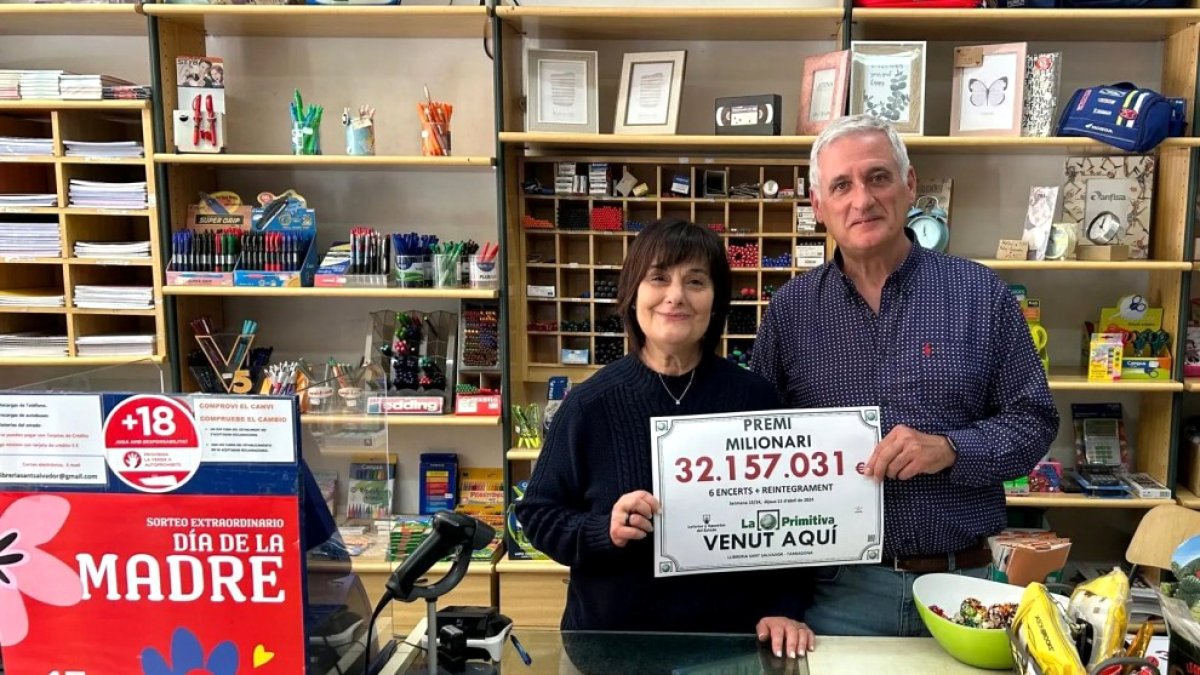 Imagen de los propietarios de la librería Sant Salvador con el número premiado.