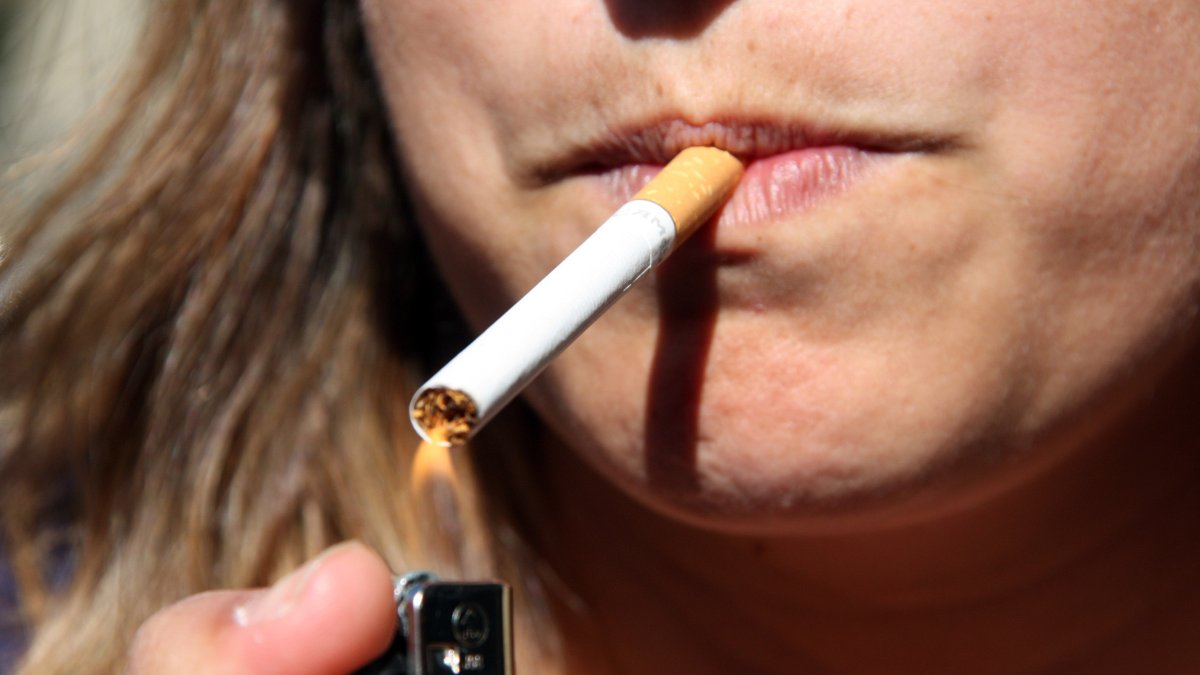 Imatge d'arxiu d'una dona encenent un cigar