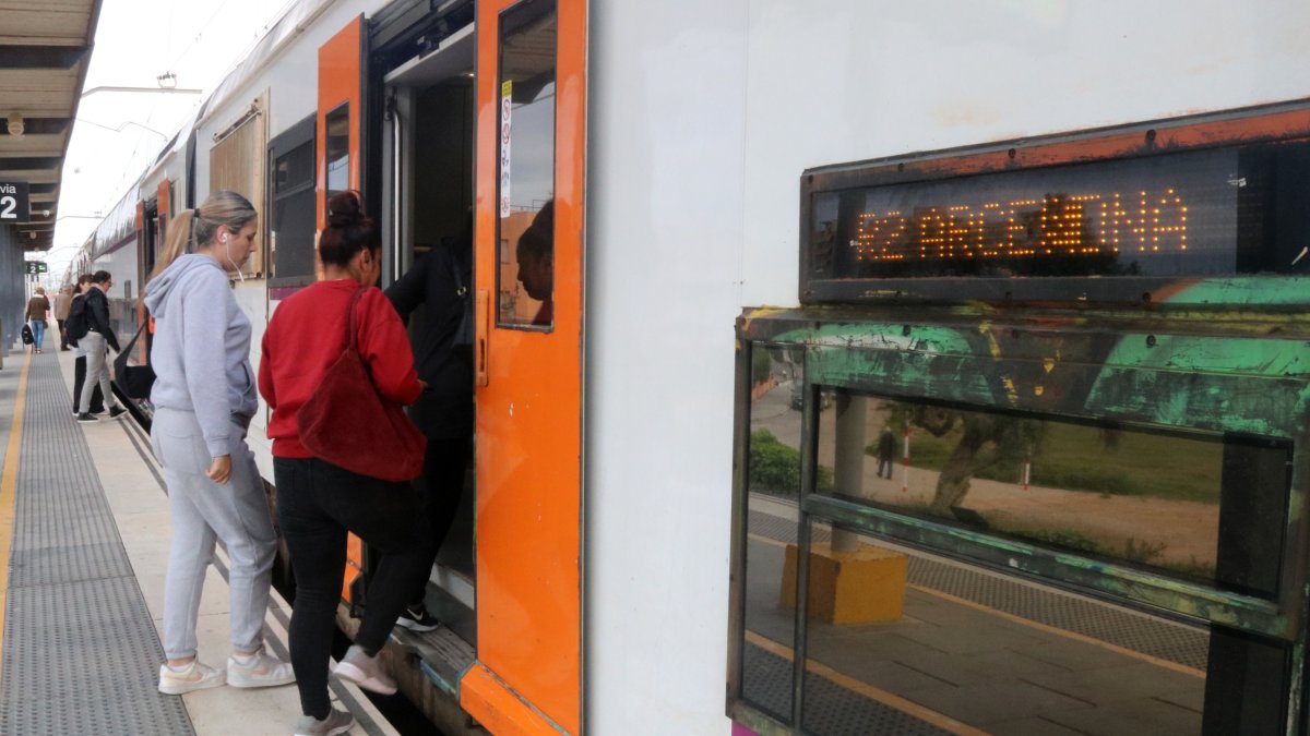 Usuaris de l'R2Sud a l'estació de Cunit accedint a un tren en direcció Barcelona.