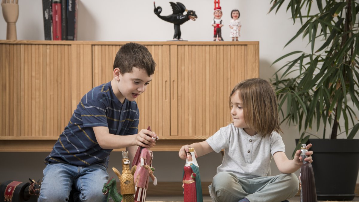 Dos niños juegan con las figuras del Àliga de Reus, la Geganta del Pi de Barcelona y los Gegants de Mataró entre otros.