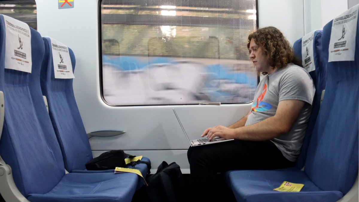 Un usuari de Rodalies treballant dins el tren