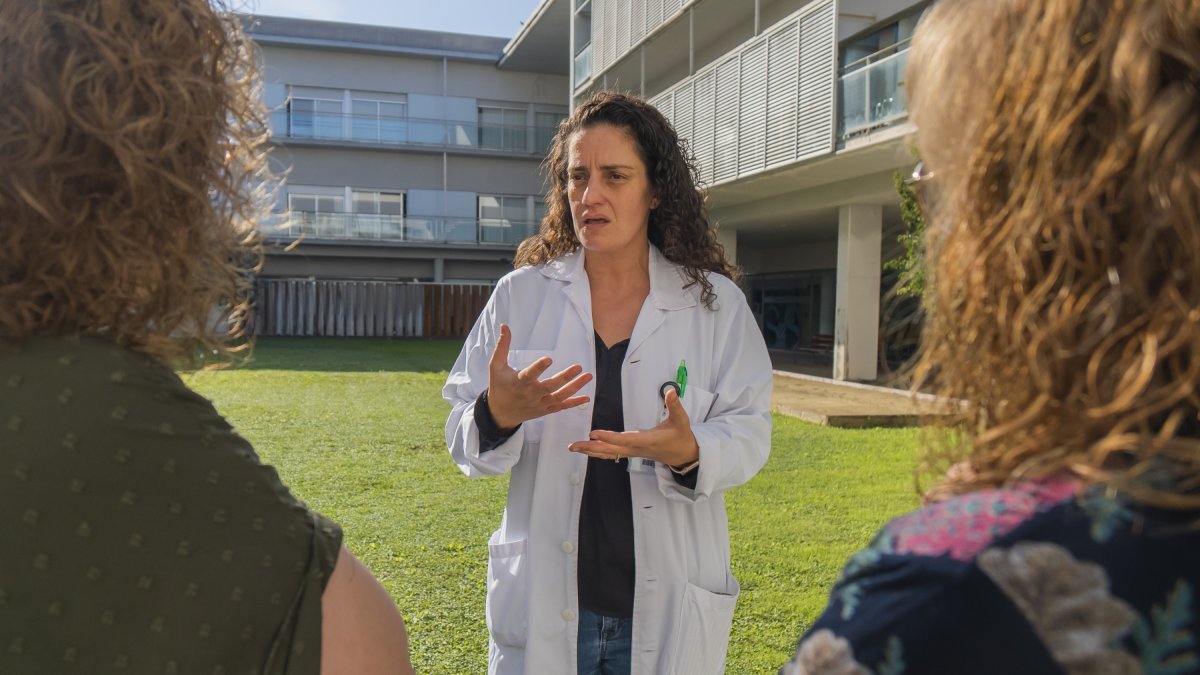 Immaculada Lillo, coordinadora y psicóloga del programa de acompañamiento, hablando con dos familiares de un paciente.