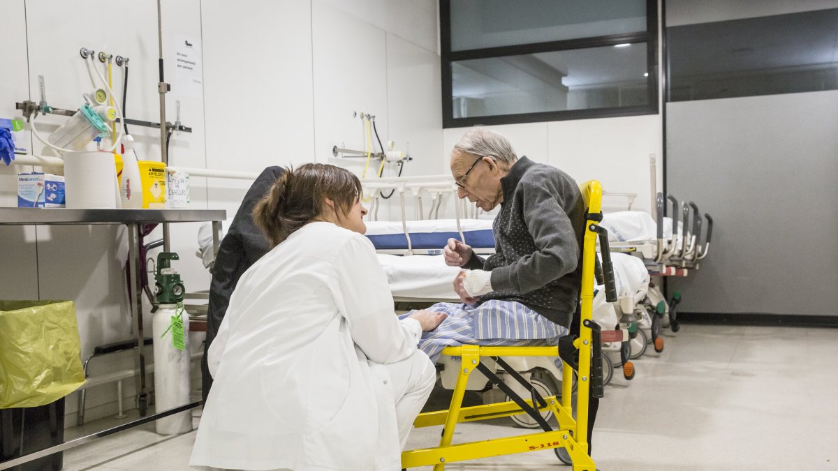 Una infermera acompanyant a una persona atesa a urgències.