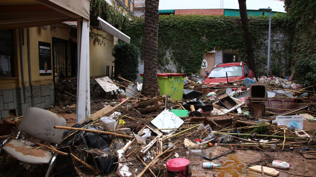 Un cotxe encastat a la terrassa d'un restaurant de Picanya i de brutícia duta per la barrancada.