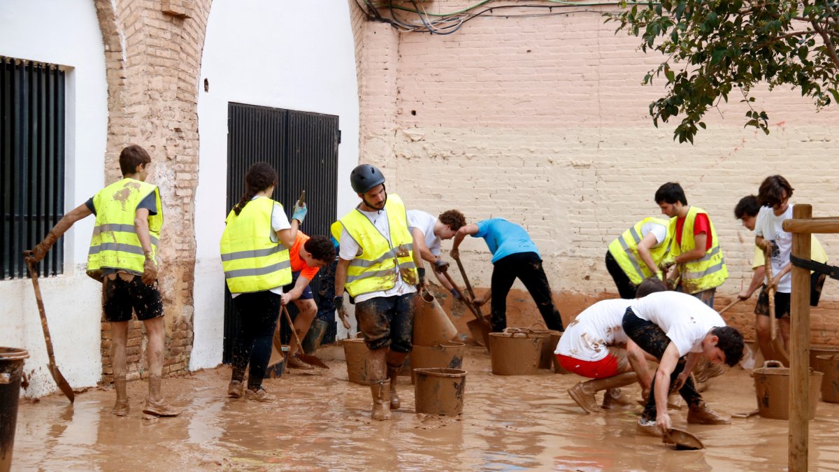 Varias personas haciendo tareas de limpieza en el barrio de La Torre de Valencia afectado por la DANA.