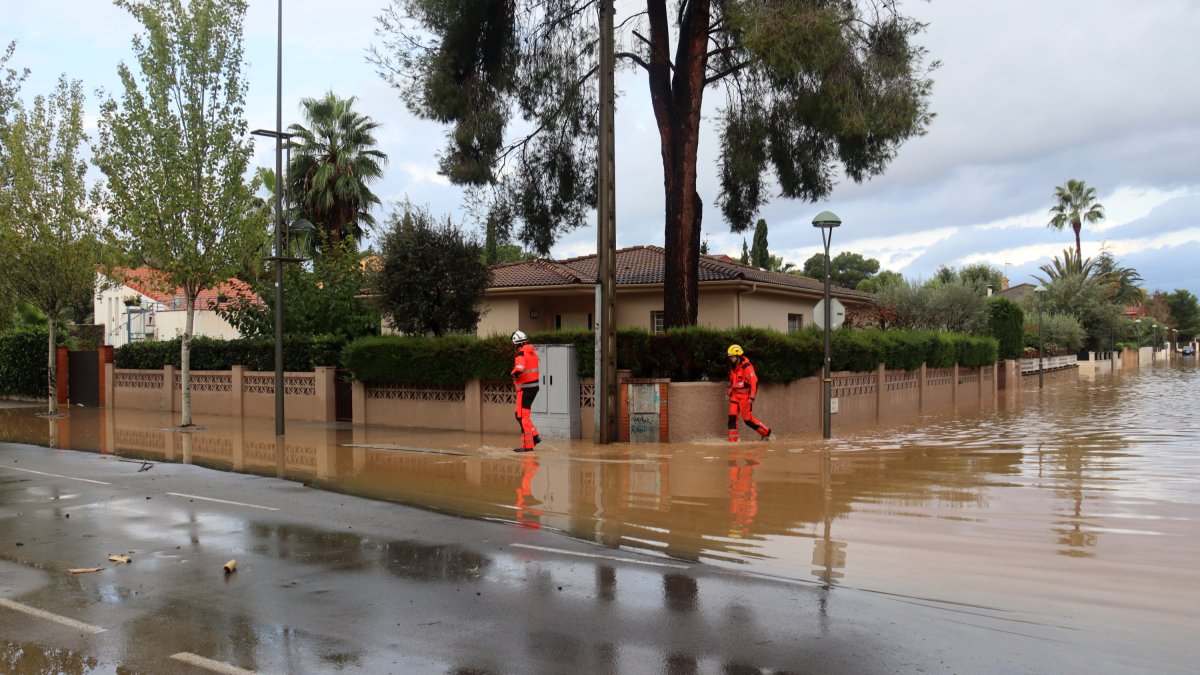 Dos bombers treballant en les inundacions de la urbanizacióo de La Móra de Tarragona