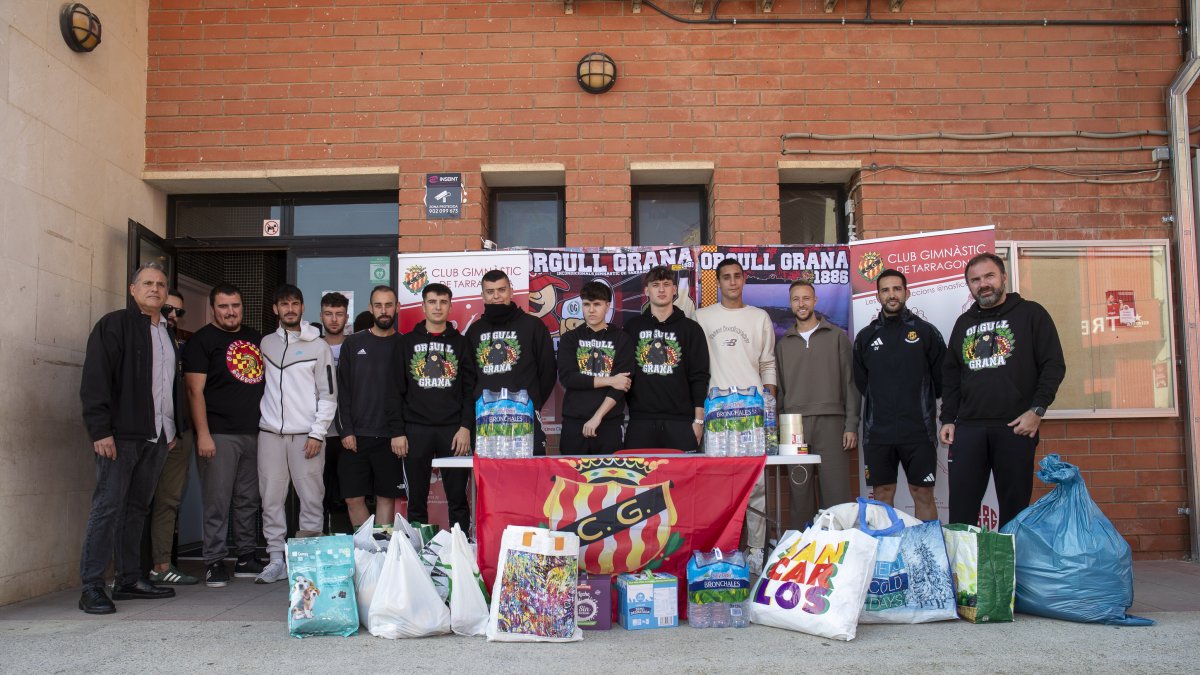 Miembros del Orgull Grana y los jugadores del Nàstic con el material recogido para los afectados de la DANA
