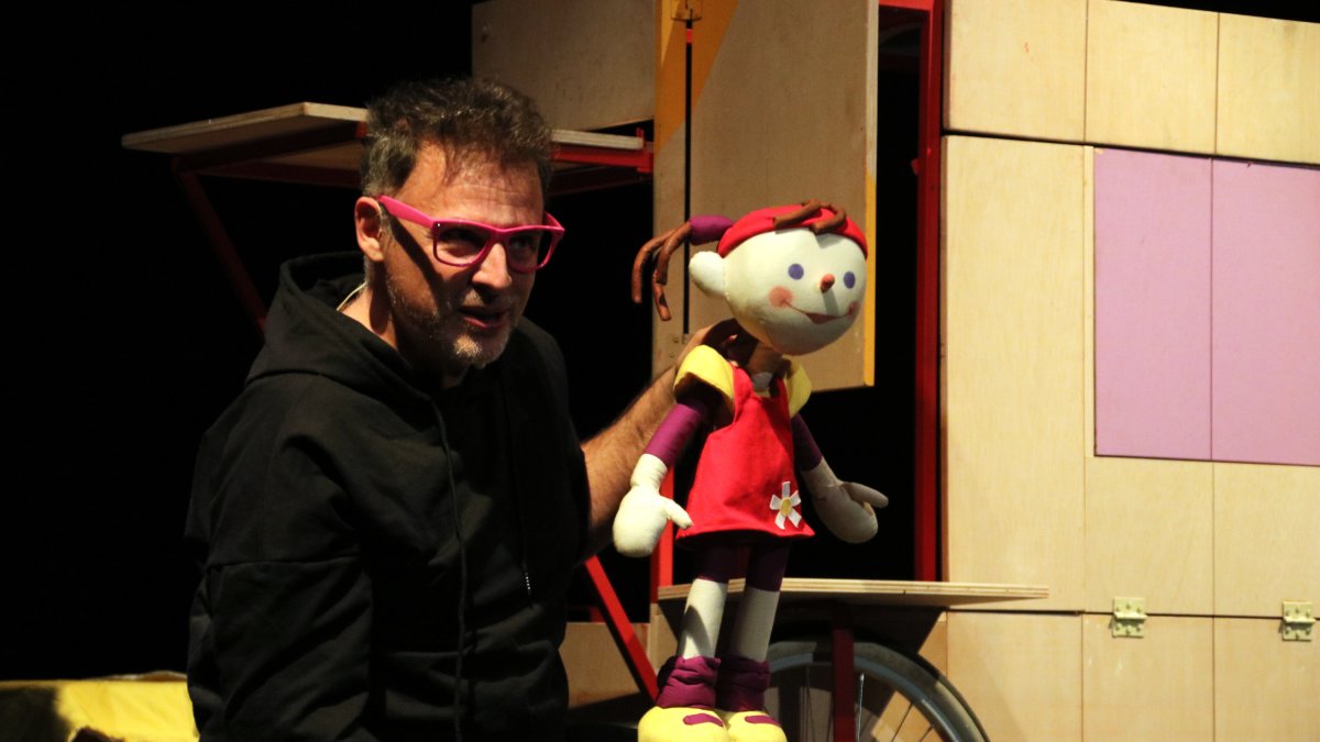 El actor y uno de los títeres actuando en la obra 'Se vende hermano pequeño', creada por el Centro de Títeres de Lleida, al inicio del festival Guante.