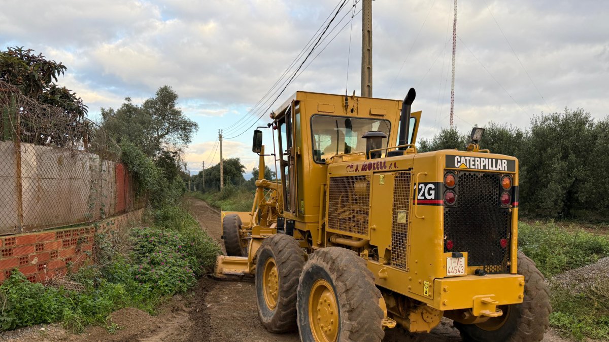 Una máquina trabajando para arreglar un camino dañado por la DANA.