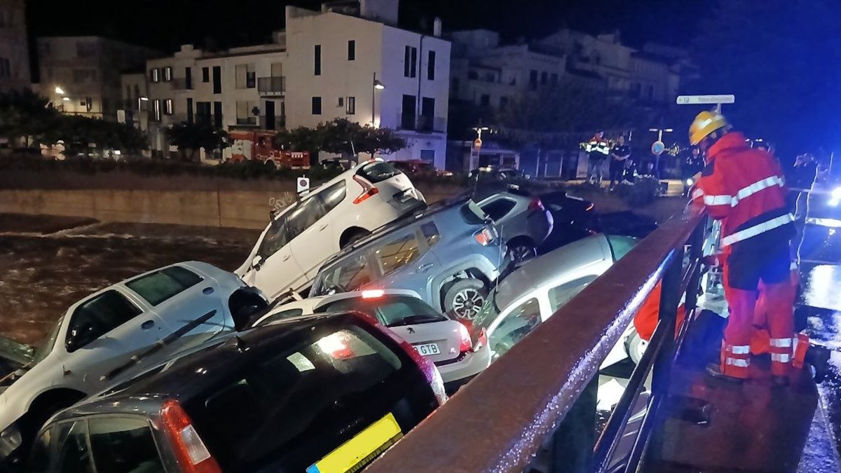 Vehicles arrossegats per la riera a Cadaqués, taponant un pont.