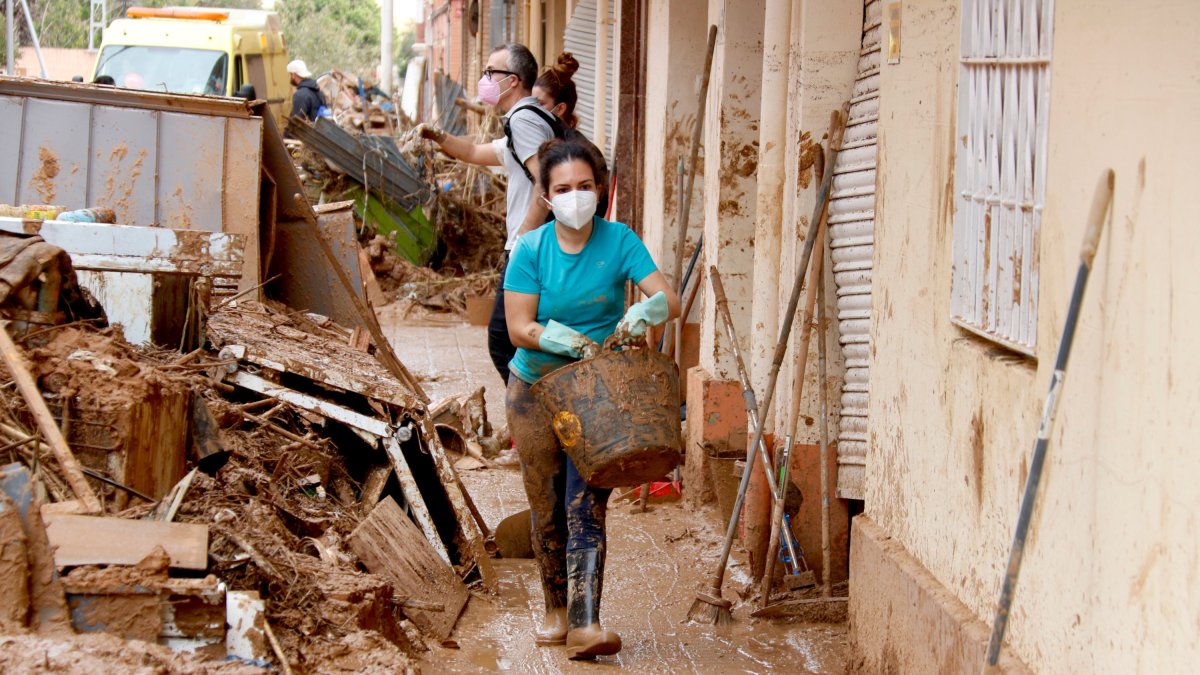 Una vecina saca un cubo de barro en Paiporta
