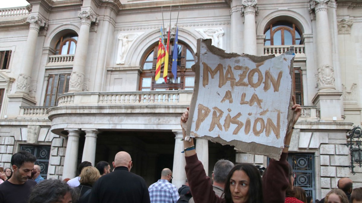Una manifestant demana la dimissió de Mazón, davant l'Ajuntament de València.
