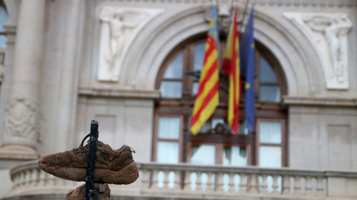 Zapatillas deportivas manchadas de barro delante del Ayuntamiento de Valencia