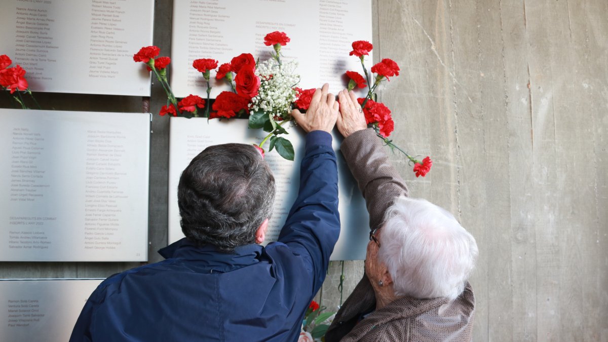 La Magda García, veïna de Viladecans, col·loca un clavell a la placa on es recorda el seu pare, un dels combatents de la batalla de l'Ebre