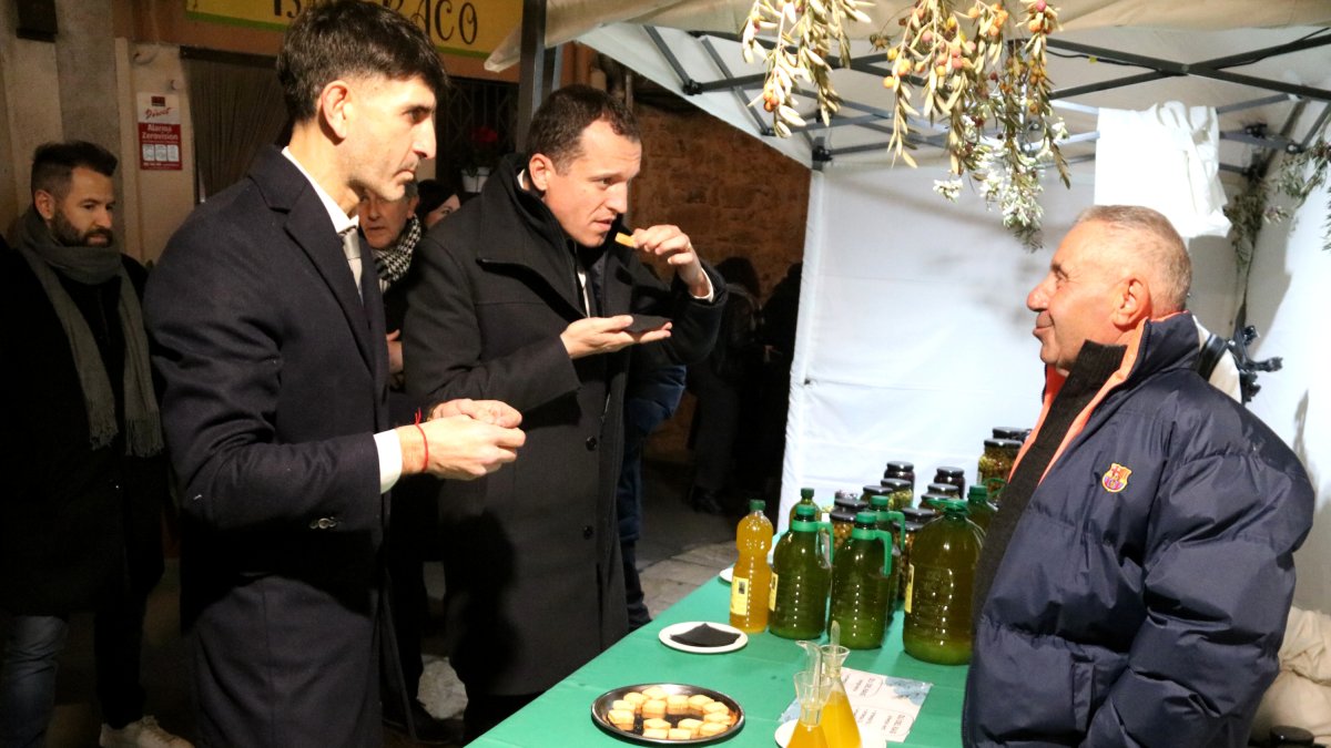 El conseller Òscar Ordeig y el alcalde de la Fatarella, Jordi Rius, probando un aceite en un estand de la Fiesta del Aceite