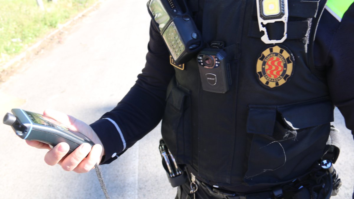 Imagen de un agente de la Guardia Urbana de Tarragona con un alcoholímetro.