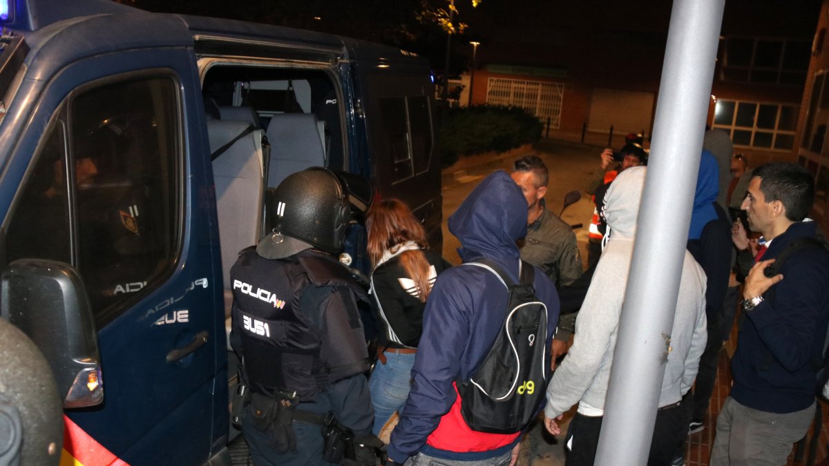 Una joven detenida subiendo a la furgoneta de la Policía Nacional, rodeada de agentes, durante los disturbios del 17 de octubre del 2019.