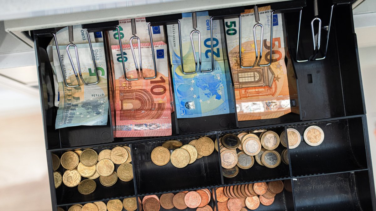 Imatge d'arxiu de bitllets i monedes en una caixa