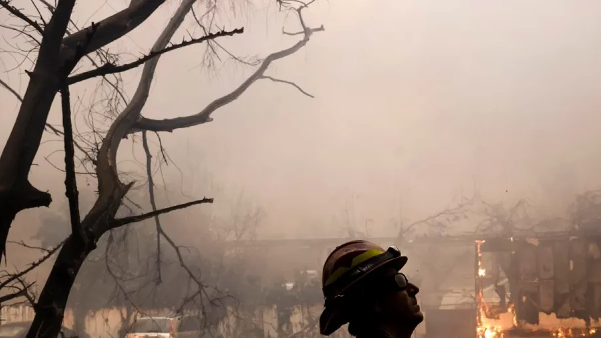 Un bomber del comtat de Los Ángeles observa un incendi a Altadena, Califòrnia.
