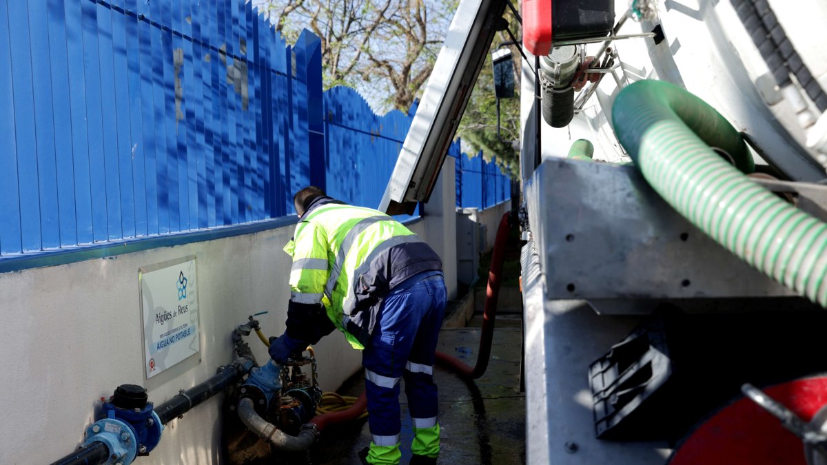 Un operari càrrega aigua no potable per a neteja.