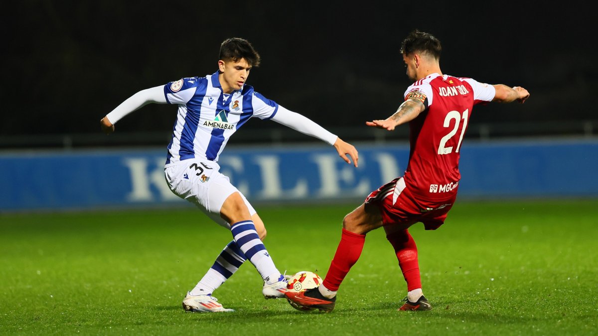 El jugador de la Real Sociedad B, Ibai Cabo, disputando el esférico con el capitán del Nàstic, Joan Oriol.