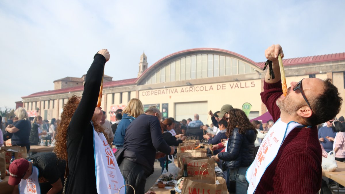 Una pareja de Altafulla come calçots en el marco de la Gran Fiesta de la Calçotada en Valls
