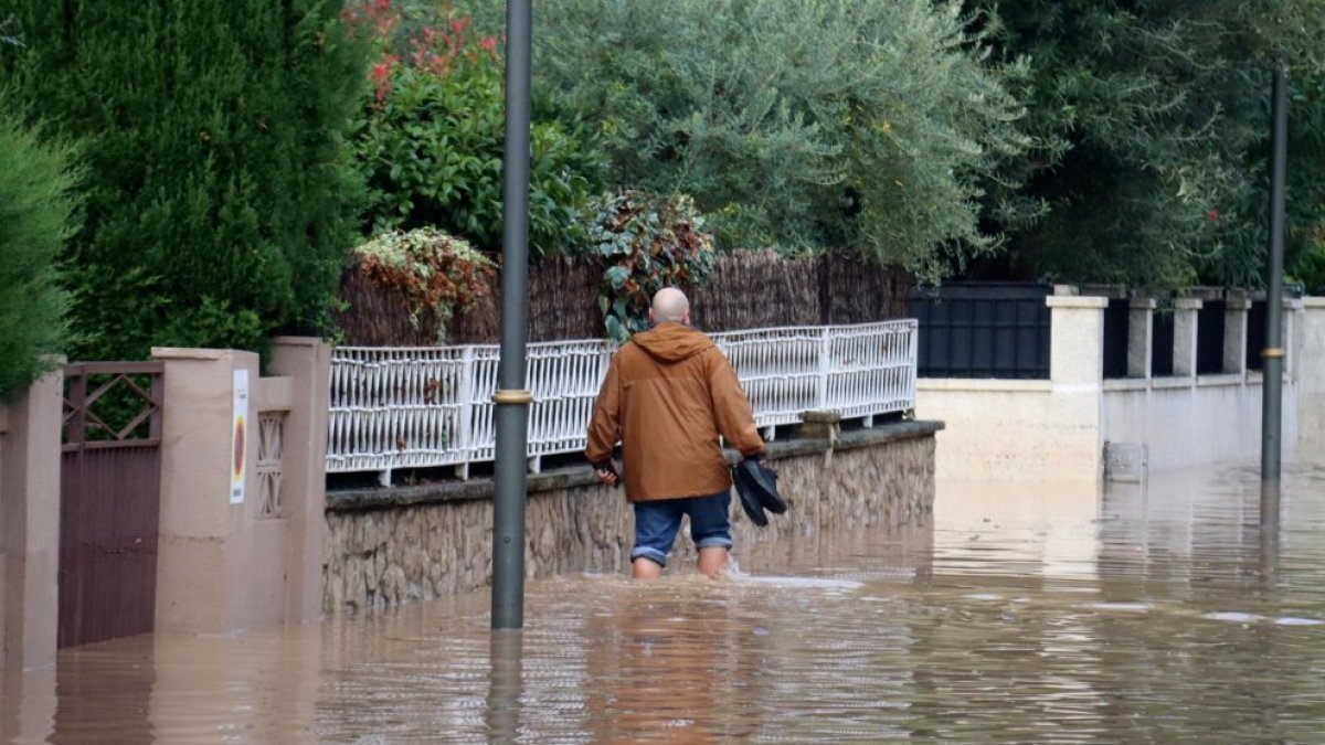 Imatge d’arxiu d’un home caminant per un carrer inundat a la Móra.