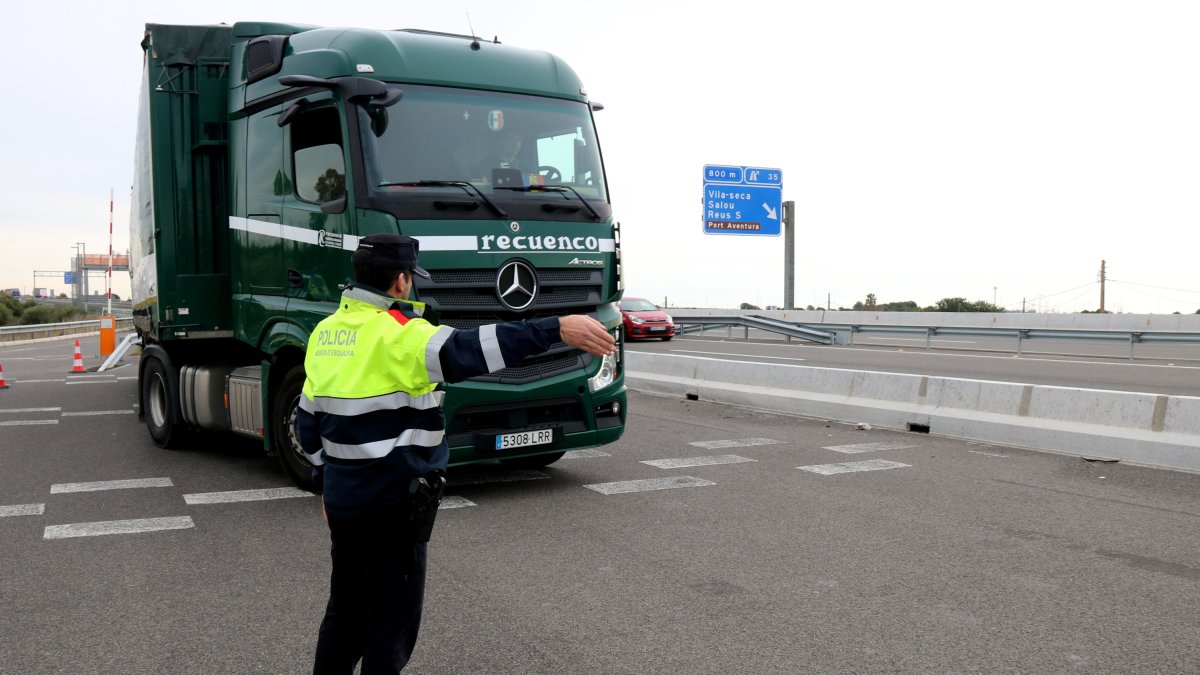 Un agente de los Mossos orienta uno de los conductores parados en el control de la AP-7 en Salou.