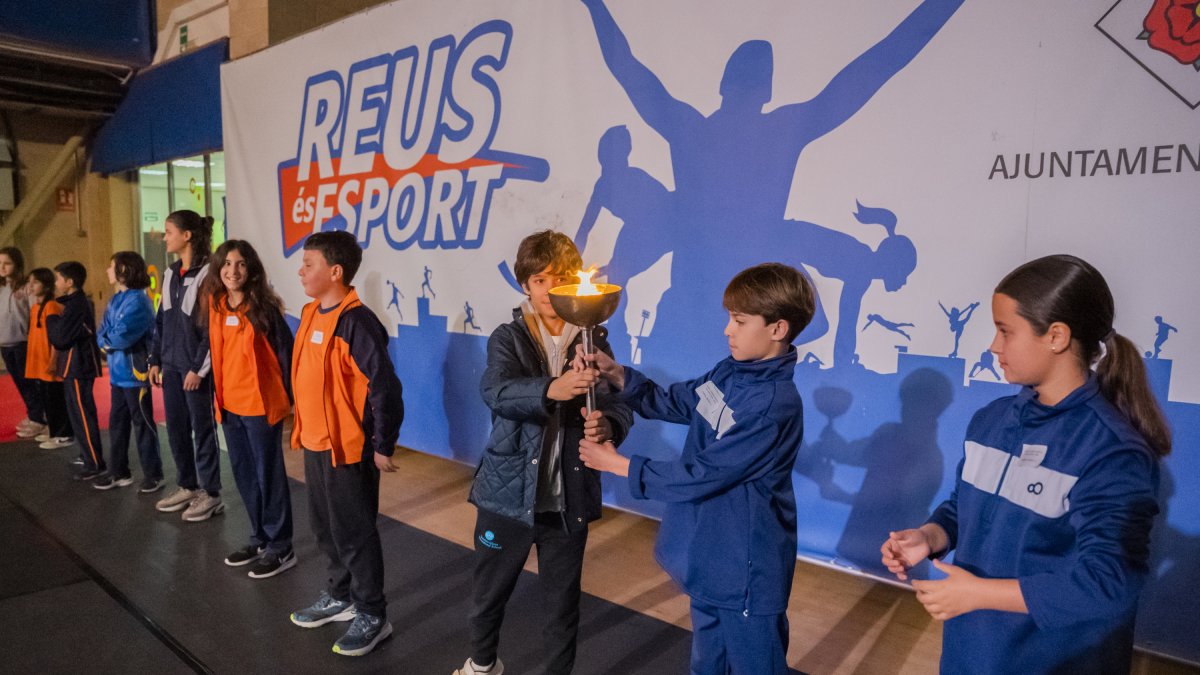 Los capitanes de las diferentes escuelas pasándose la antorcha olímpica antes de encender el pebetero.