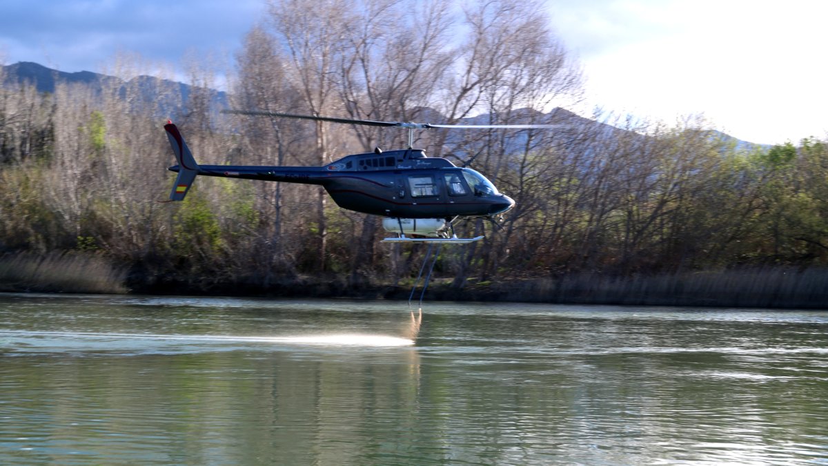 Un helicòpter fumiga les larves de mosca negra al riu Ebre, a Xerta.