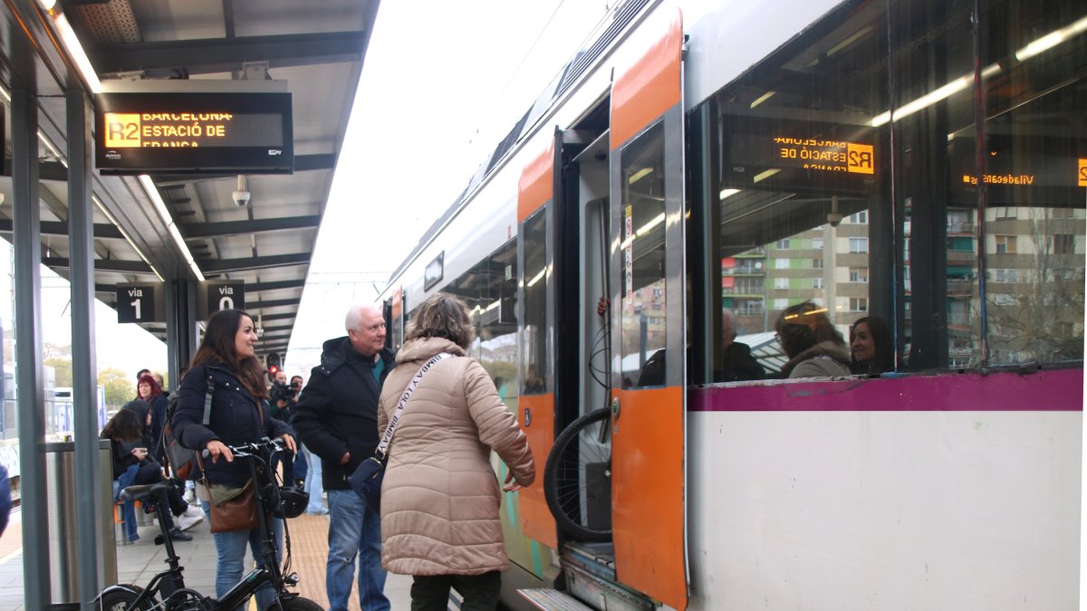 Varios pasajeros subiendo en un tren a la estación de Bellvitge-Gornal que va dirección Barcelona