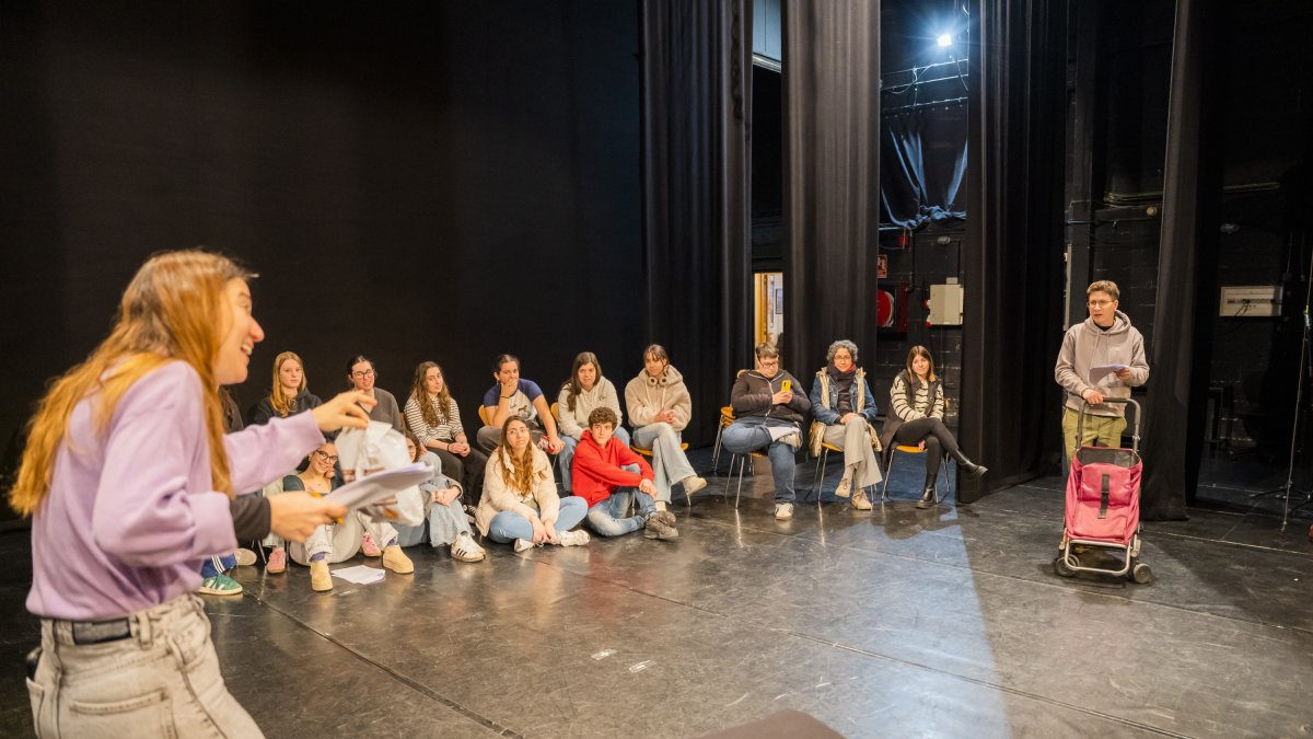 Fotografia dels actors assajant davant l’atenta mirada dels alumnes de l’Institut Gabriel Ferrater i Soler.