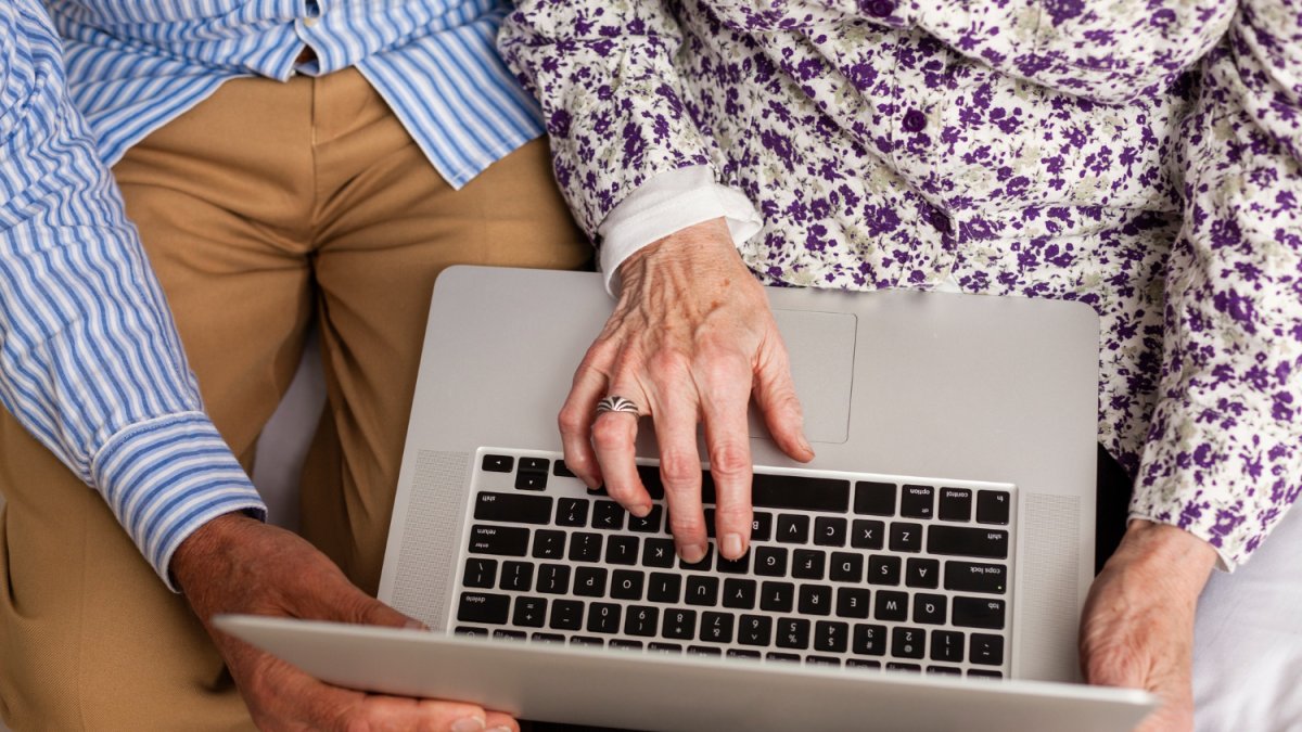 Personas de edad avanzada manipulan un ordenador portátil.