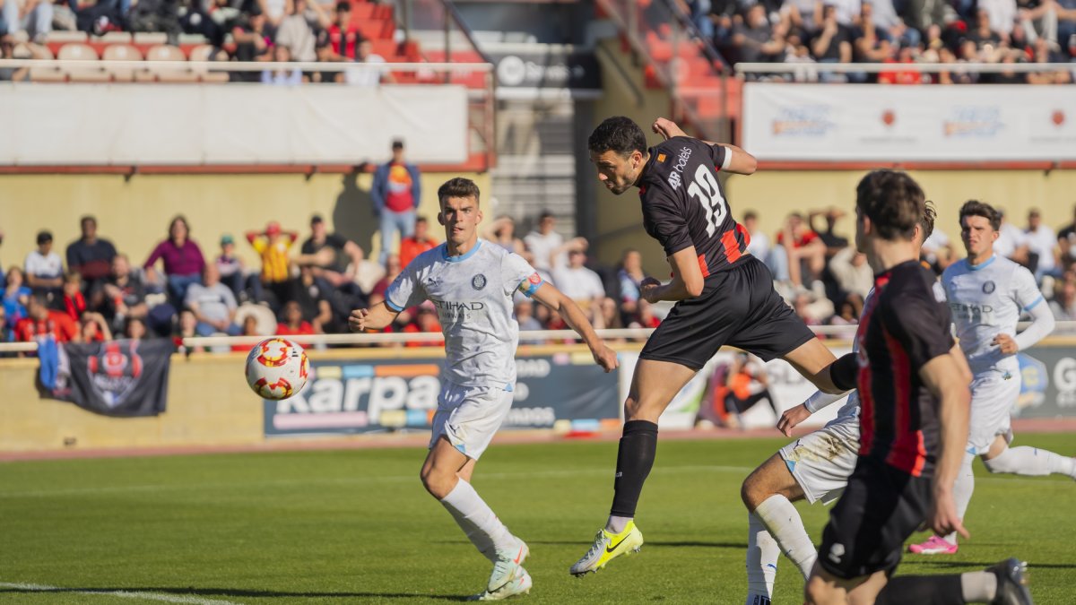 El defensor Andy Alarcón rematant una centrada durant el duel contra el Girona B.