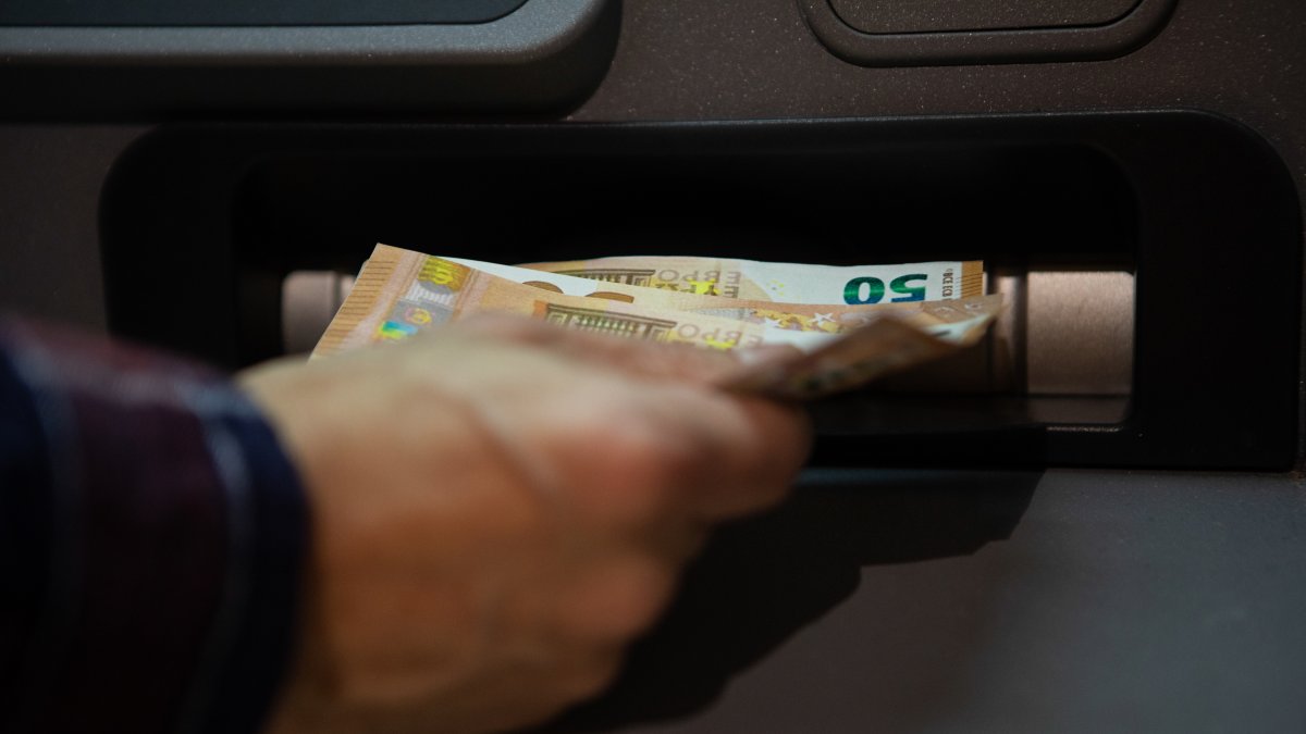 Una persona que retira dinero de un cajero automático