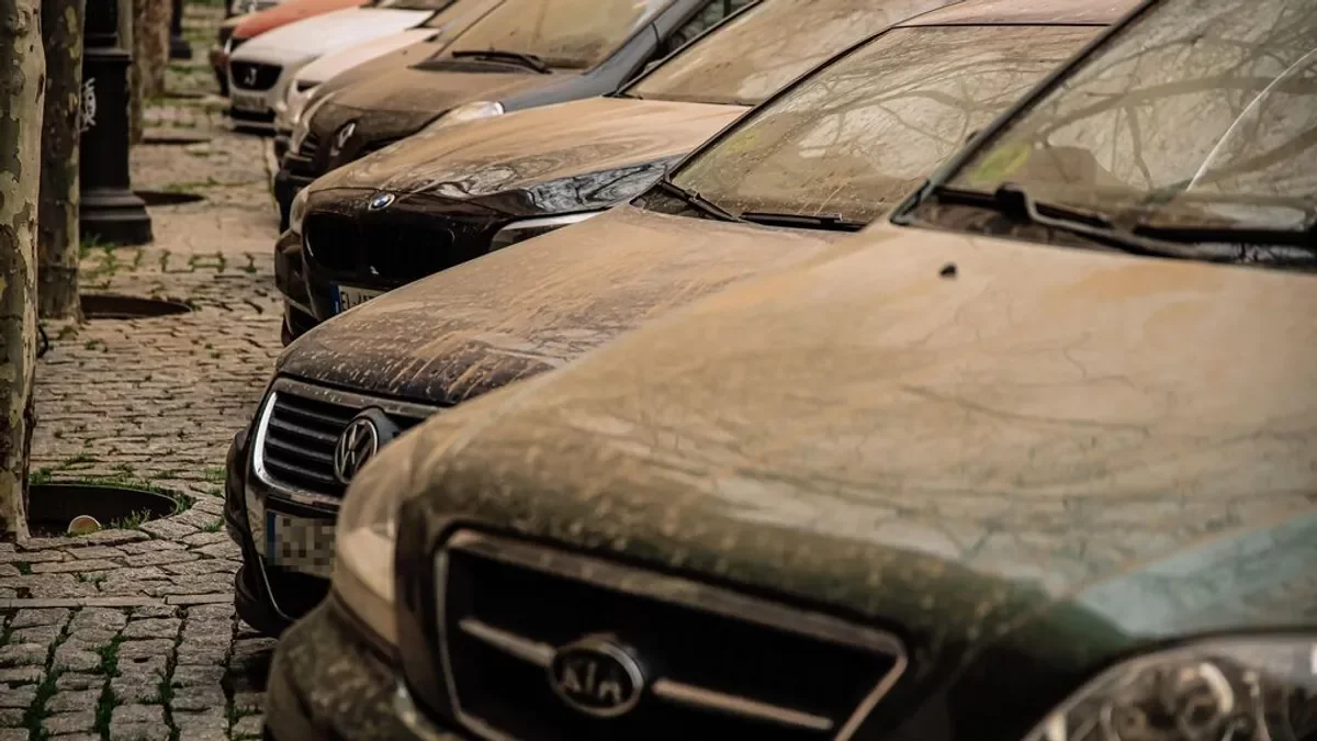 Imagen de varios coches llenos de barro tras el paso de una lluvia de sangre.