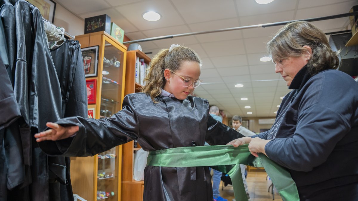 Una joven probándose la túnica y la faja para participar en la Semana Santa