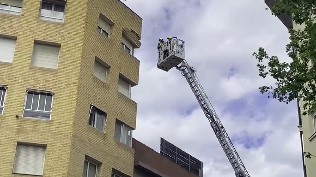 Bombers treballant a la façana afectada al carrer Jaume I de Reus.