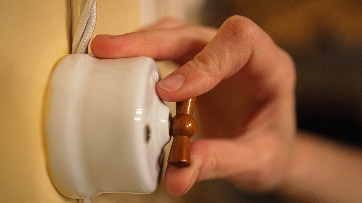 Una persona abre el interruptor de la luz de una casa