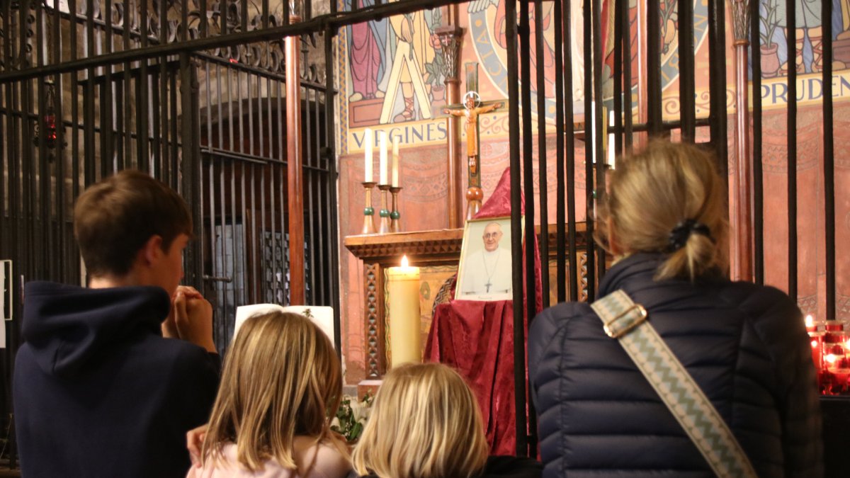 Una familia ruega ante la fotografía memorial del papa Francisco en la Capilla Santa Llúcia