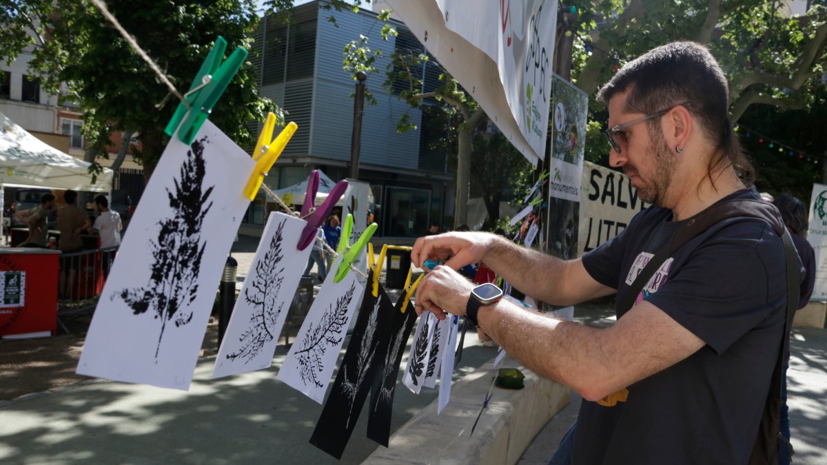 Un hombre cuelga una estampación de una hoja coincidiendo con el 40.º aniversario de Gepec-EdC en Reus
